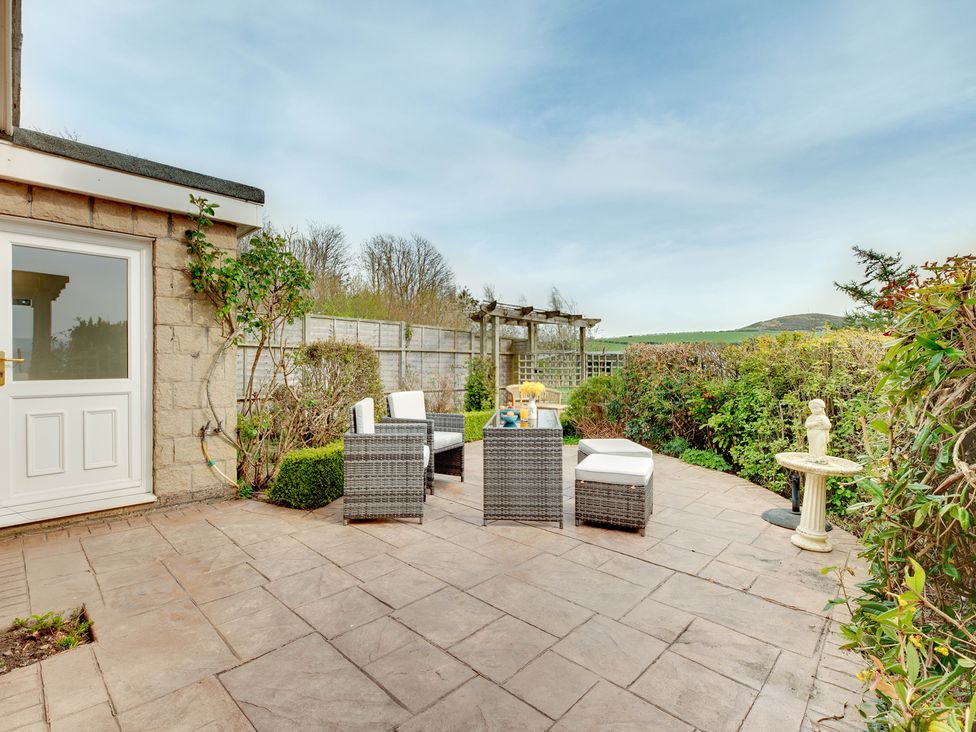 A garden patio with chairs and a table at The Granary in Alnwick