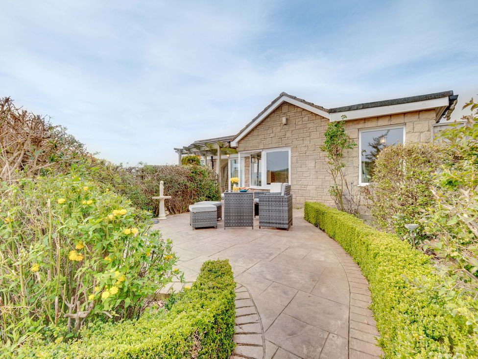 A garden with a house and patio seating area at The Granary in Alnwick