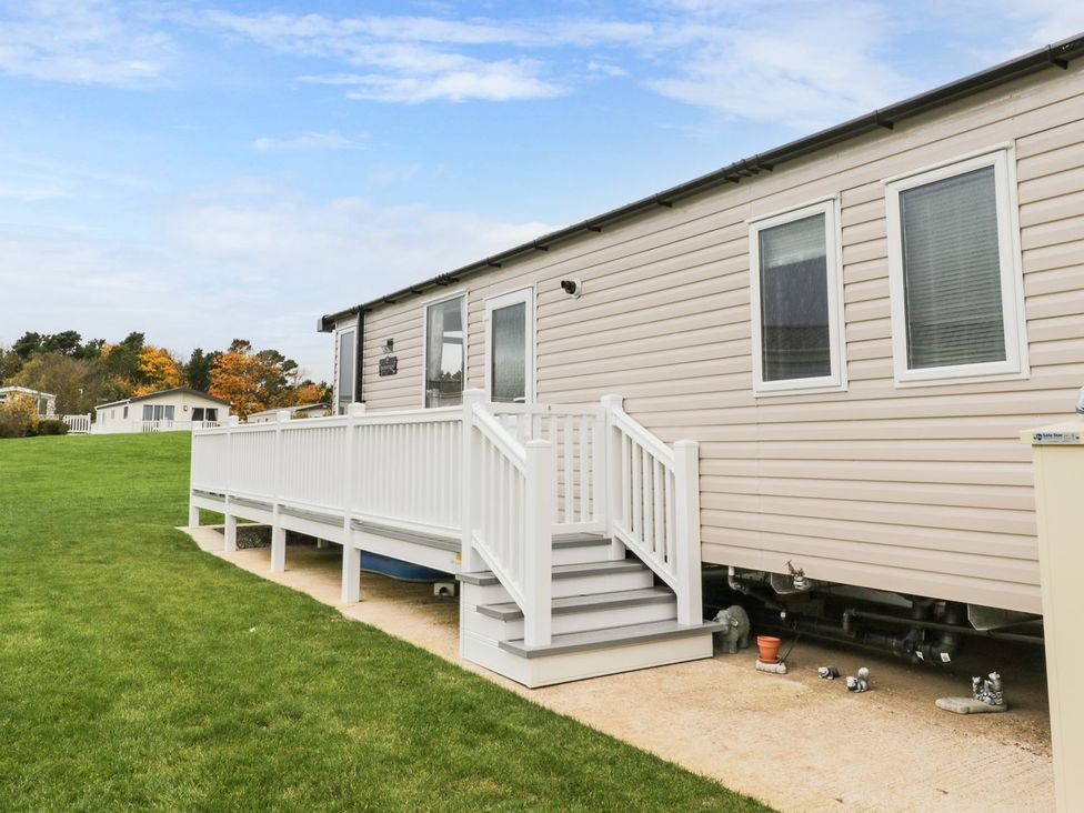 A mobile home with a deck and grass area at Kelly's Retreat in Scarborough