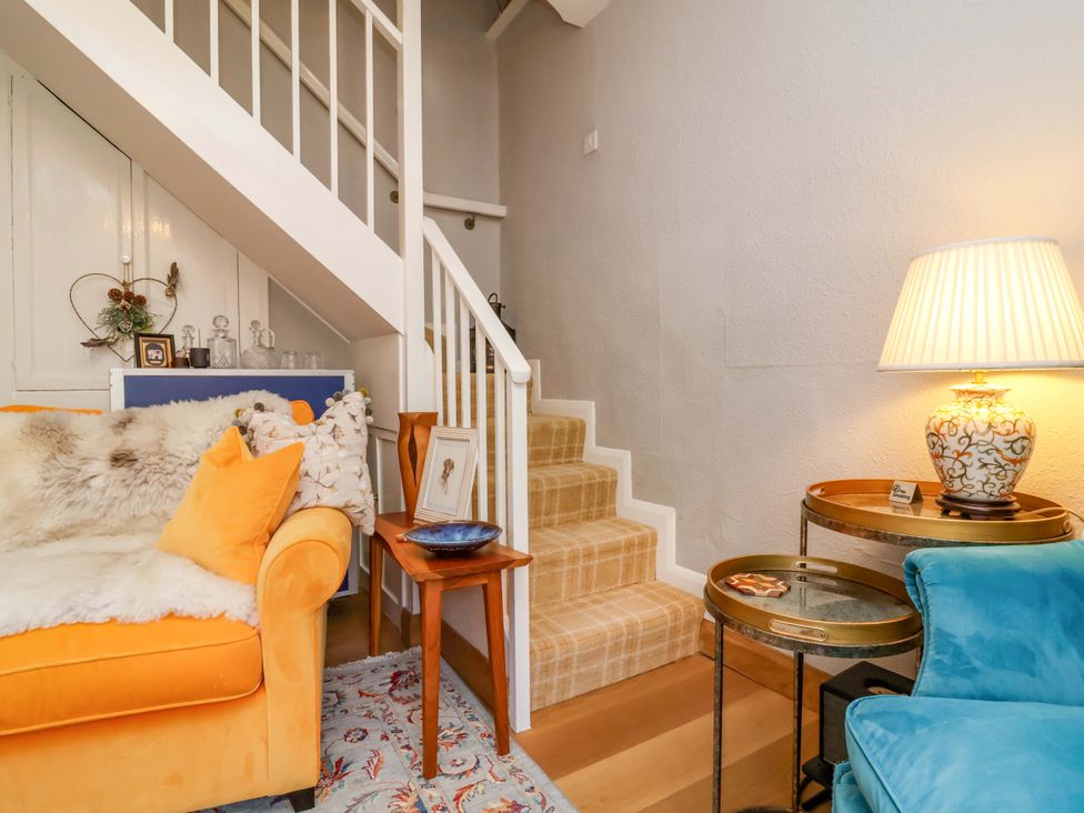A living room with a sofa and a staircase at Seacroft in Combe Martin