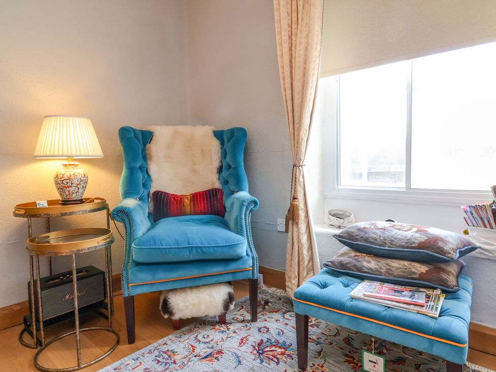 A reading nook with a chair and table at Seacroft in Combe Martin