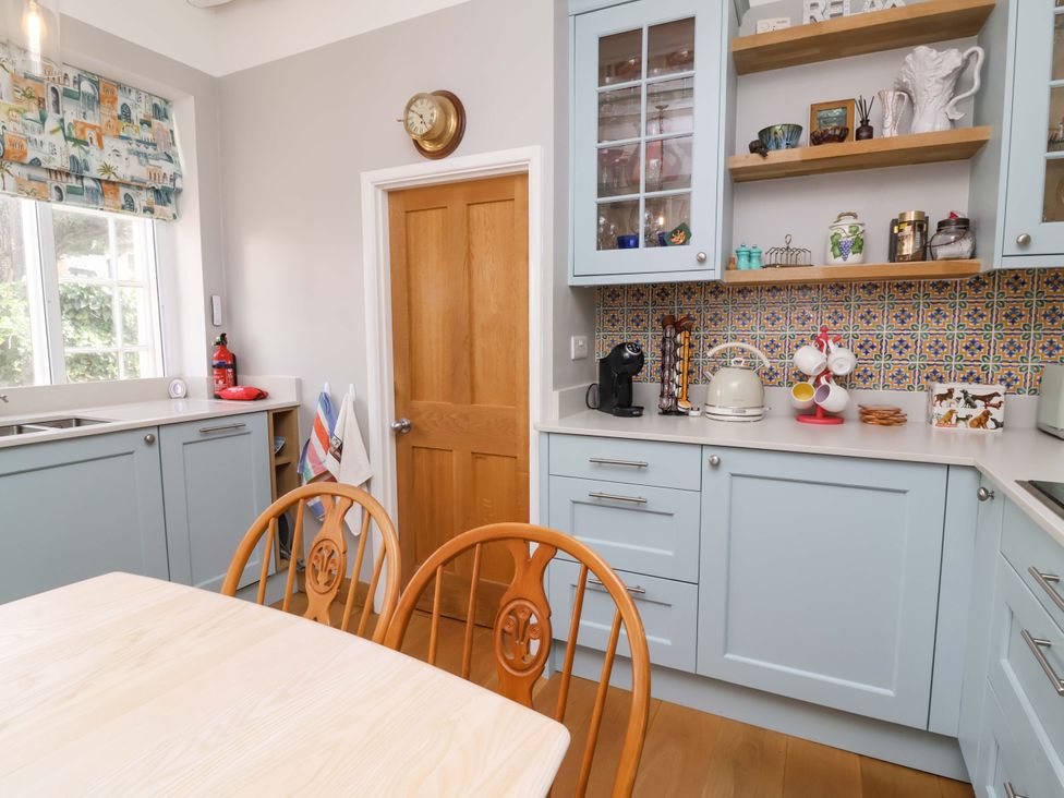 A kitchen with cabinets and a table at Seacroft Combe Martin