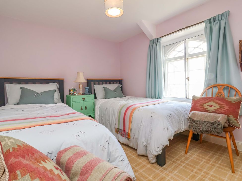 A bedroom with two beds and a window at Seacroft in Combe Martin