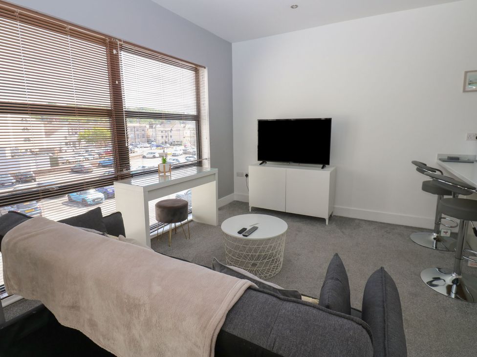 A living room with a sofa and television at Harbourside Apartments in Whitehaven