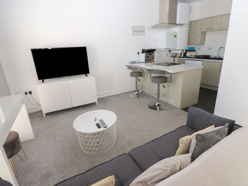 A living room with a television and kitchen island at Harbourside Apartments Whitehaven