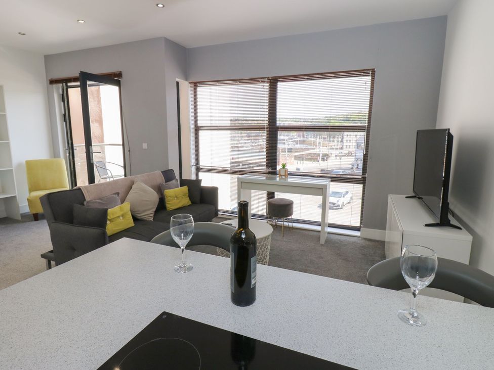 A living room with a sofa and a television at Harbourside Apartments in Whitehaven