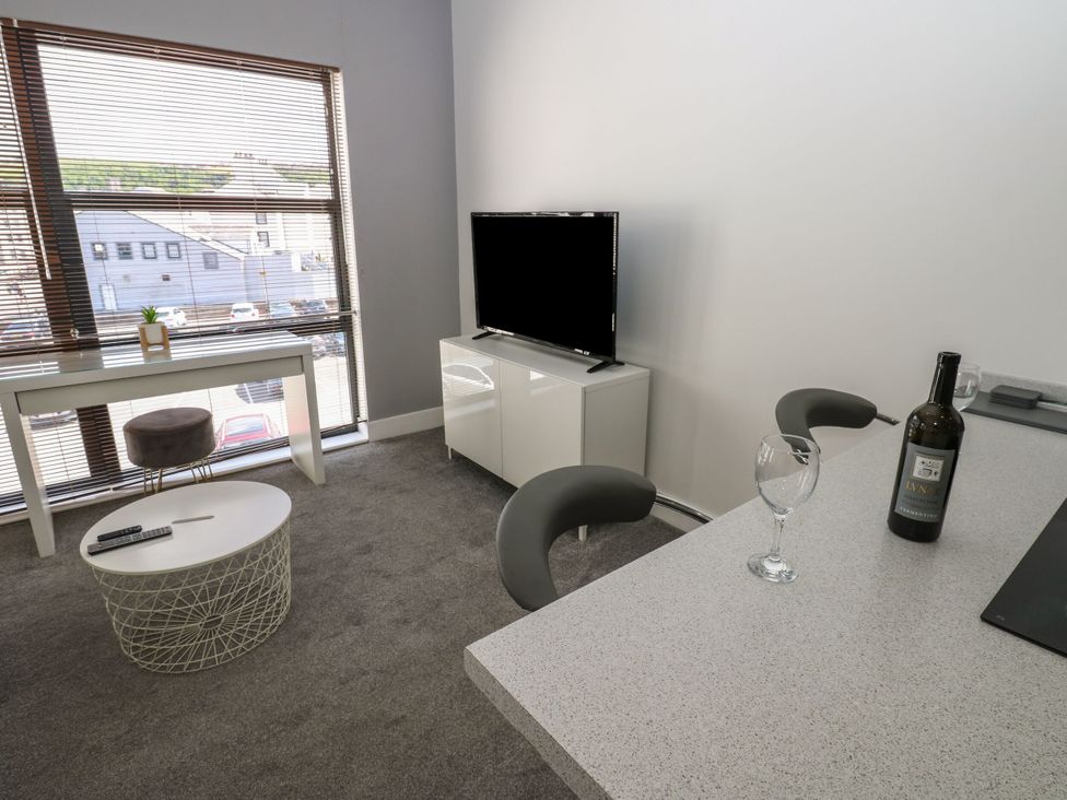 A living room with a window and television at Harbourside Apartments in Whitehaven