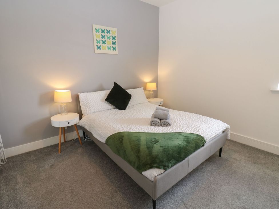 A bedroom with a bed and bedside tables at Harbourside Apartments Whitehaven