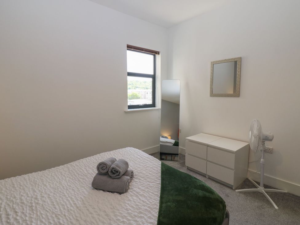 A bedroom with a bed and mirror at Harbourside Apartments in Whitehaven