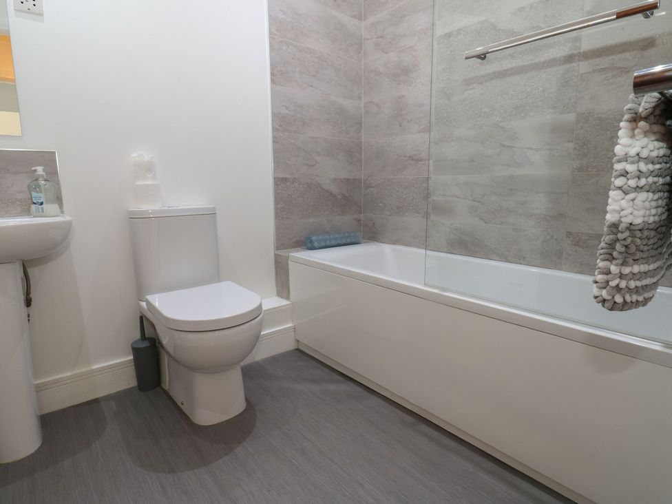 A bathroom with a sink, toilet, and bathtub at Harbourside Apartments in Whitehaven