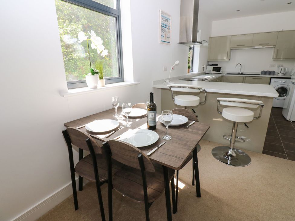 A dining room with a table and kitchen area at Seaview in Whitehaven