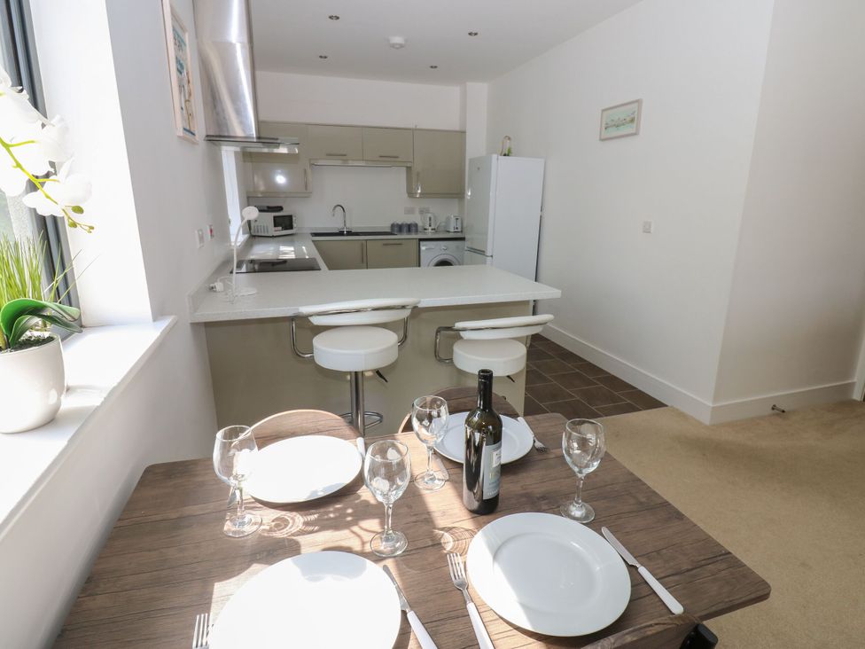 A kitchen and dining area with a table set at Seaview in Whitehaven