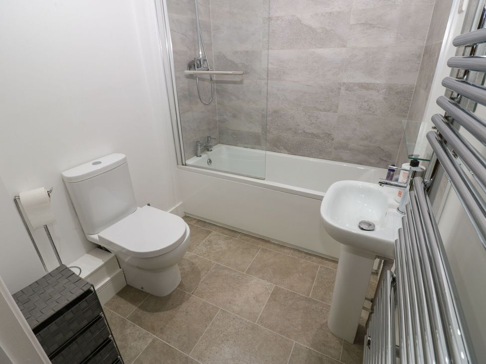 A bathroom with a bathtub, shower, toilet, and sink at Seaview in Whitehaven