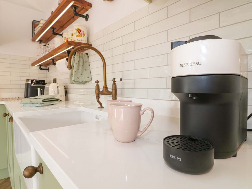 A kitchen with a coffee maker and a mug on the counter at The Canalside Cottage in Derby