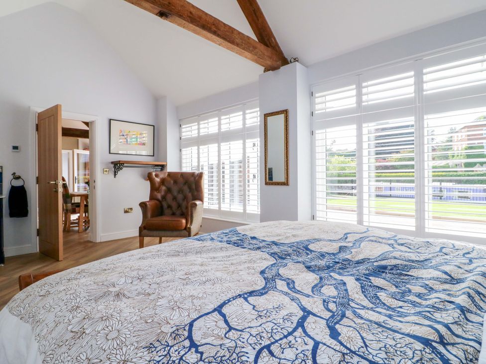 A bedroom with a bed and armchair at The Canalside Cottage in Derby