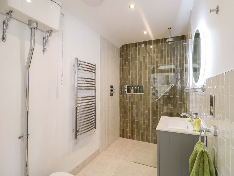 A bathroom with a shower, toilet, and sink at The Canalside Cottage in Derby