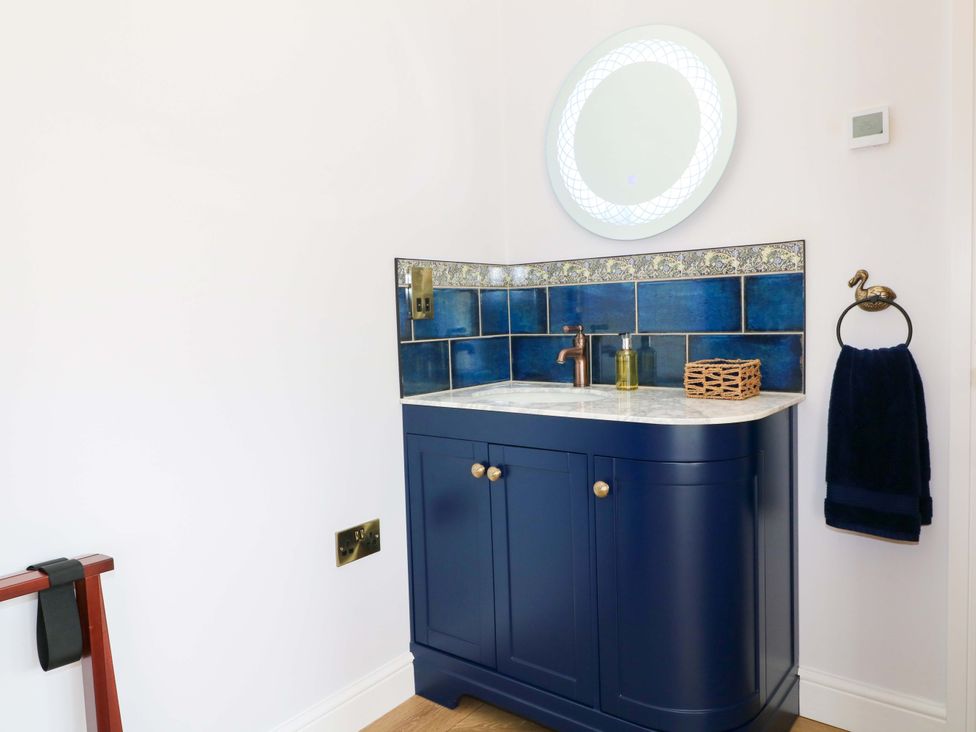 A bathroom with a sink and mirror at The Canalside Cottage, Derby