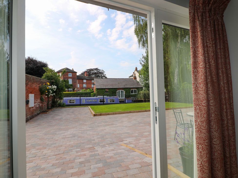 An outdoor area with a paved driveway and garden furniture at The Canalside Cottage in Derby