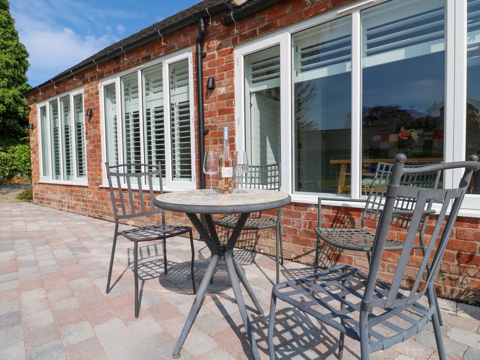 An outdoor seating area with a table and chairs at The Canalside Cottage in Derby