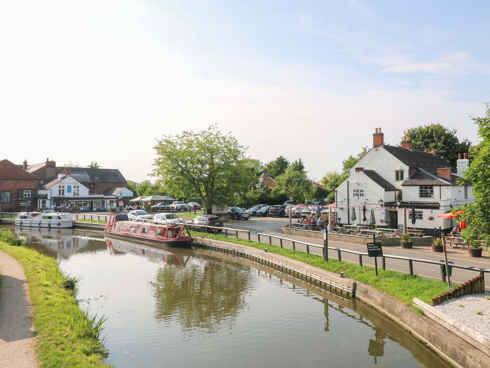 A canal with boats and buildings beside it at The Canalside Cottage in Derby