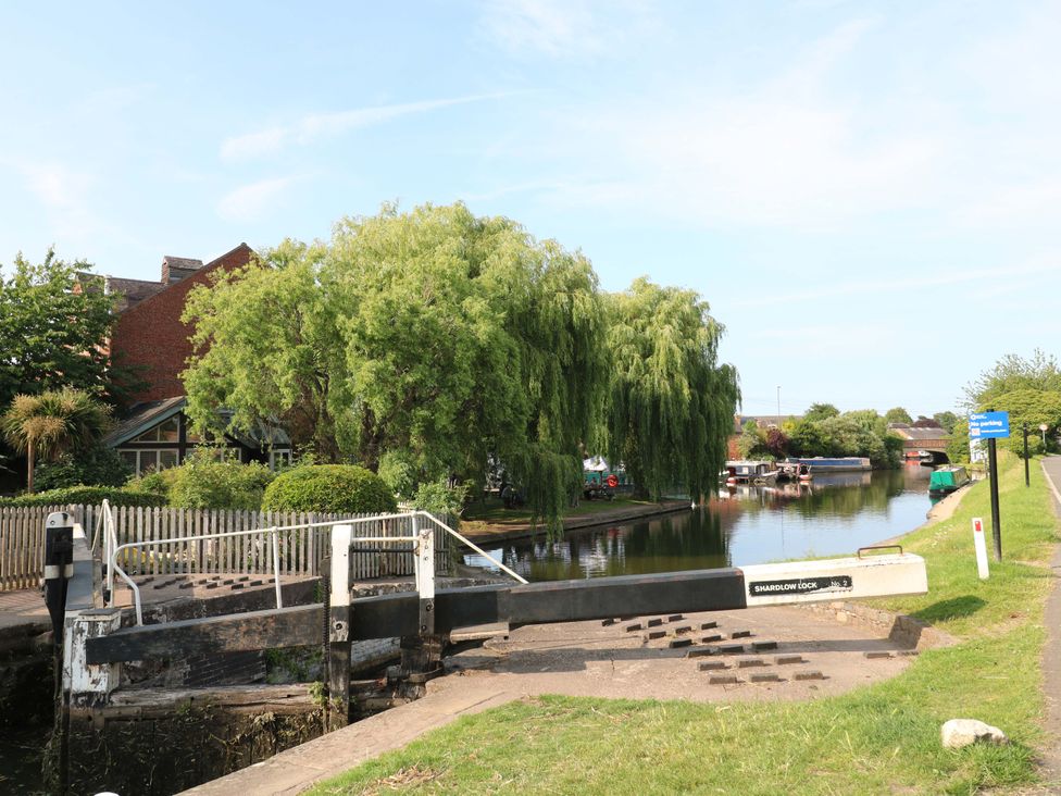 A canal with a lock and trees at The Canalside Cottage in Derby