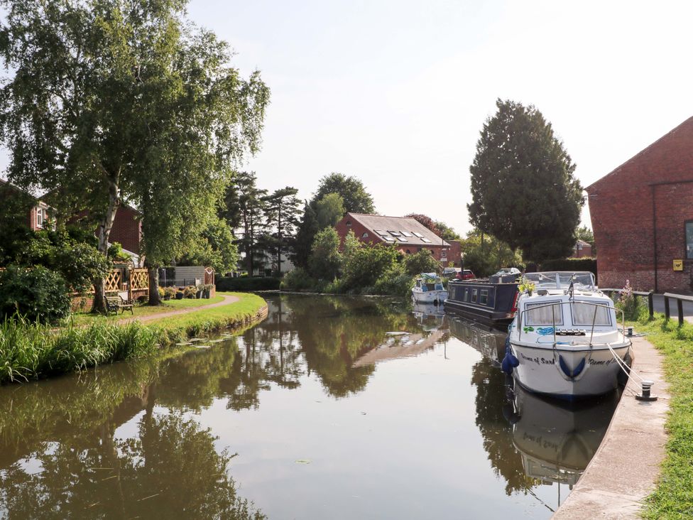 A canal with boats and houses near the water at The Canalside Cottage in Derby
