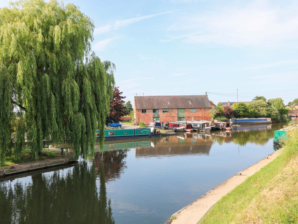 A canal with boats and a building at The Canalside Cottage in Derby