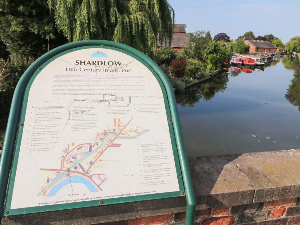 A sign describing the Shardlow inland port near a river at The Canalside Cottage in Derby