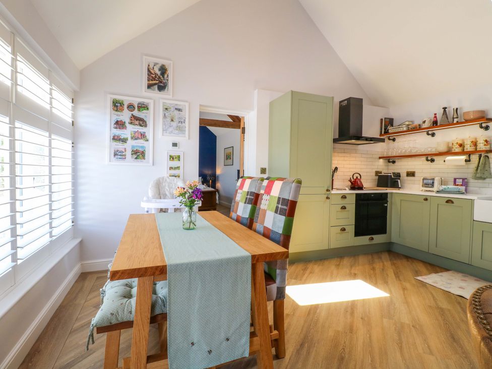 A kitchen with a table and chairs at The Canalside Cottage Shardlow near Castle Donington