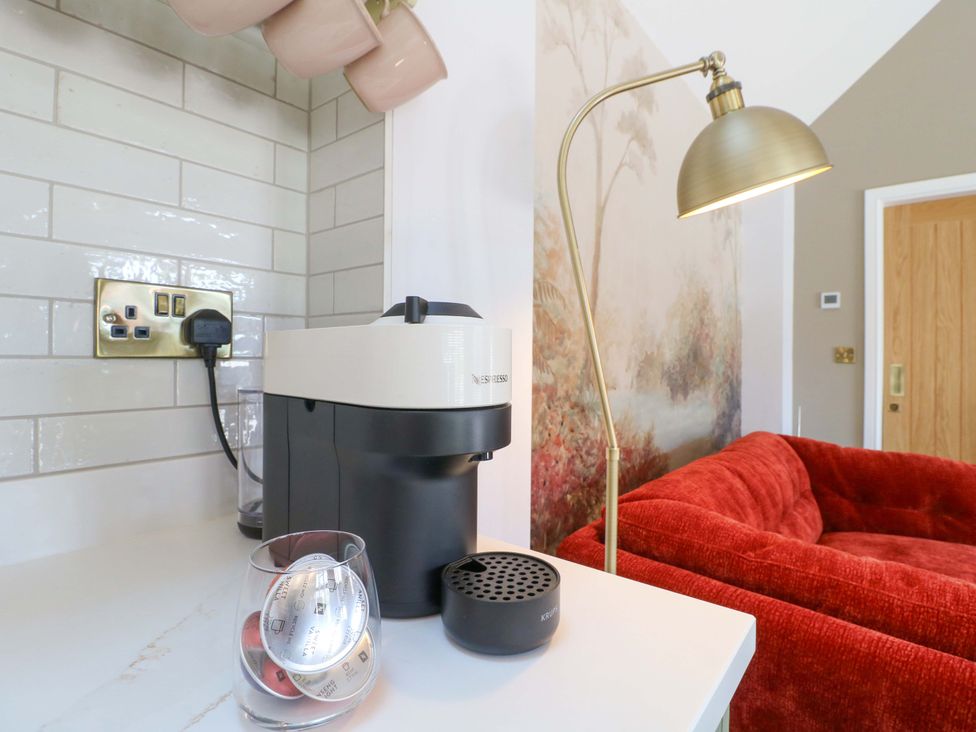 A kitchen with a coffee machine and a floor lamp at The Canalside Cottage Shardlow near Castle Donington