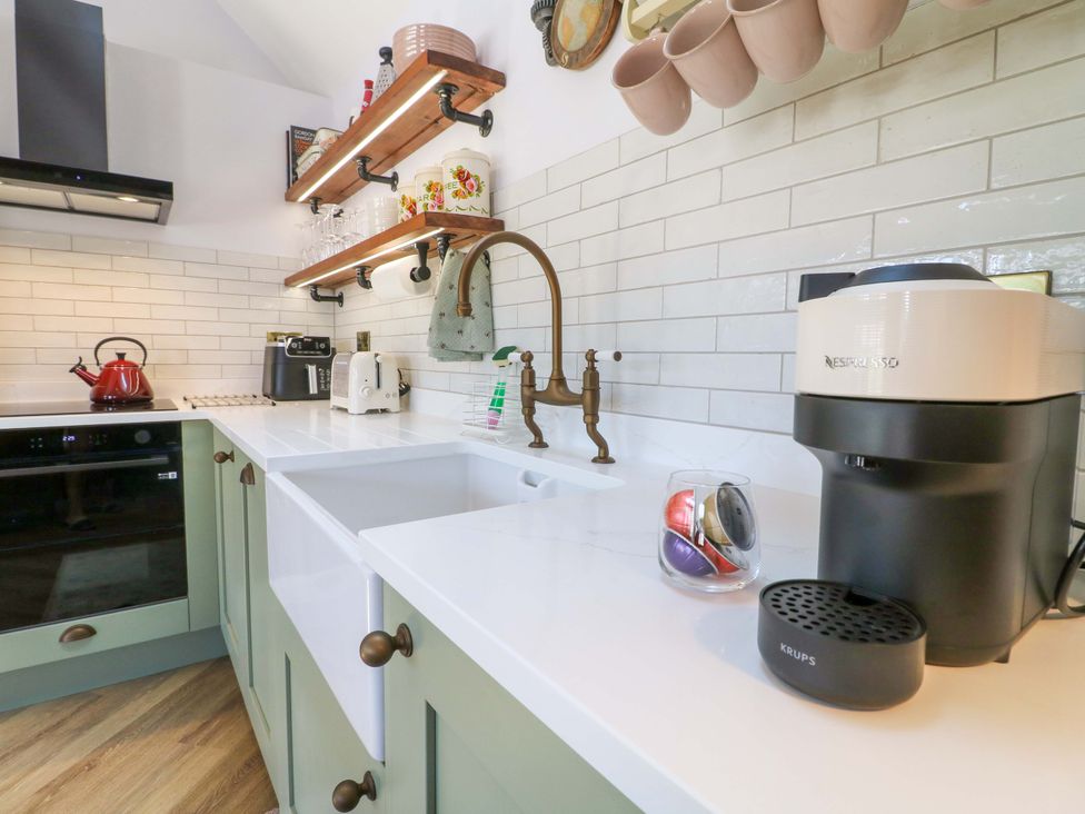 A kitchen with a sink, coffee machine, and kettle at The Canalside Cottage in Shardlow near Castle Donington