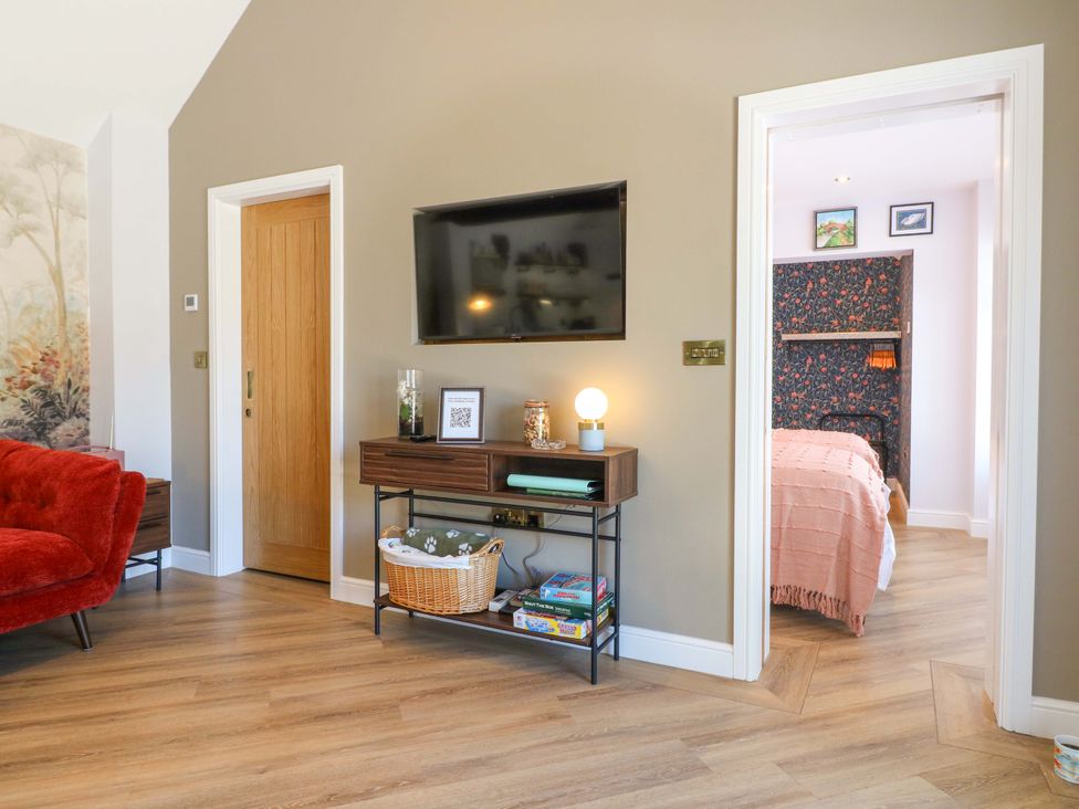 A living room with a television and sofa at The Canalside Cottage in Shardlow near Castle Donington