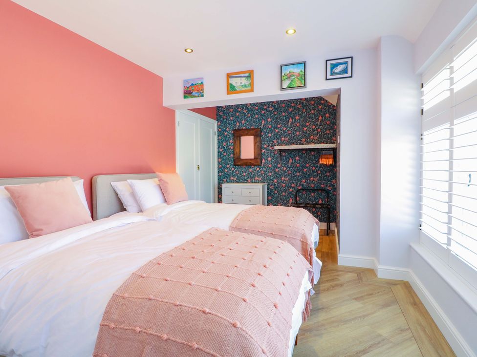A bedroom with two beds and pictures on the wall at The Canalside Cottage in Shardlow near Castle Donington