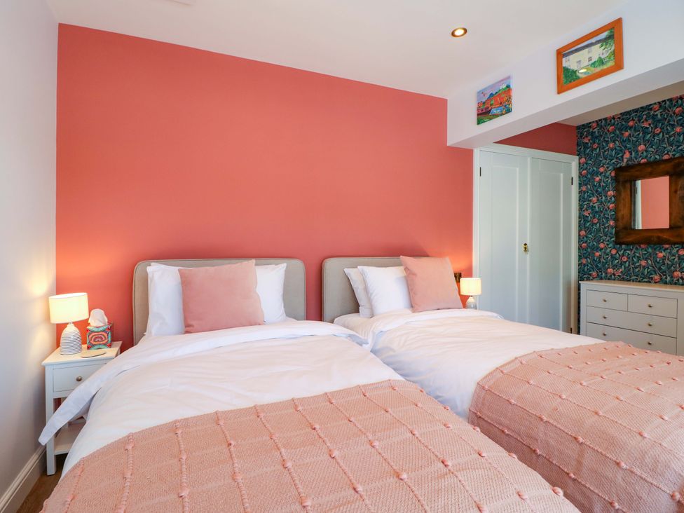 A bedroom with two beds and a bedside table at The Canalside Cottage in Shardlow near Castle Donington