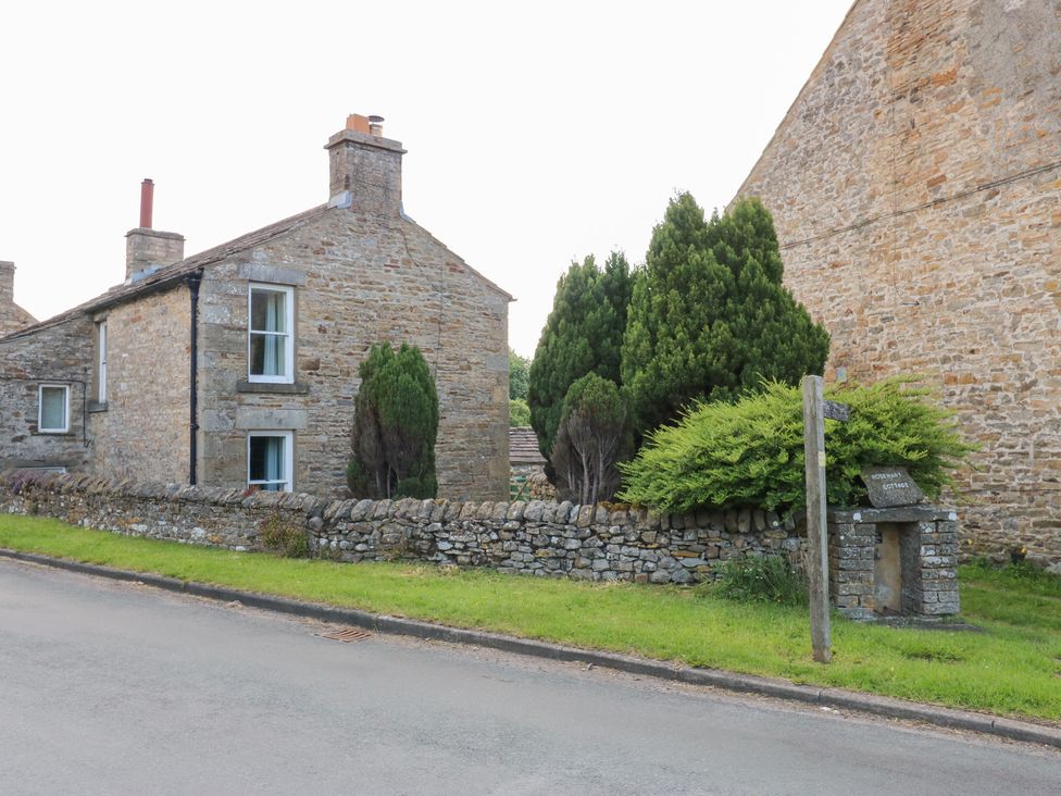 A stone house with trees in front at Rosemary Cottage Leyburn