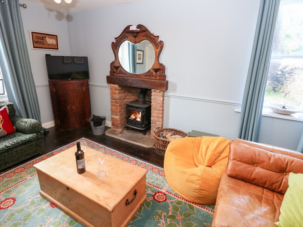 A living room with a fireplace and a television at Rosemary Cottage in Leyburn