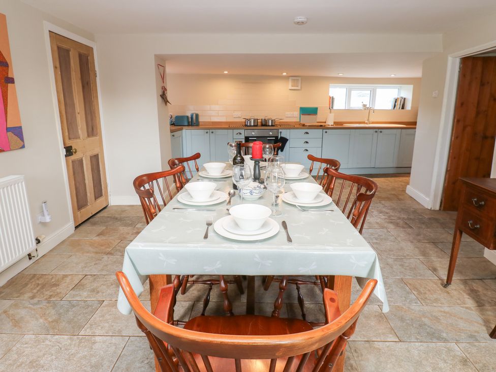 A dining room with a table set for meals at Rosemary Cottage in Leyburn