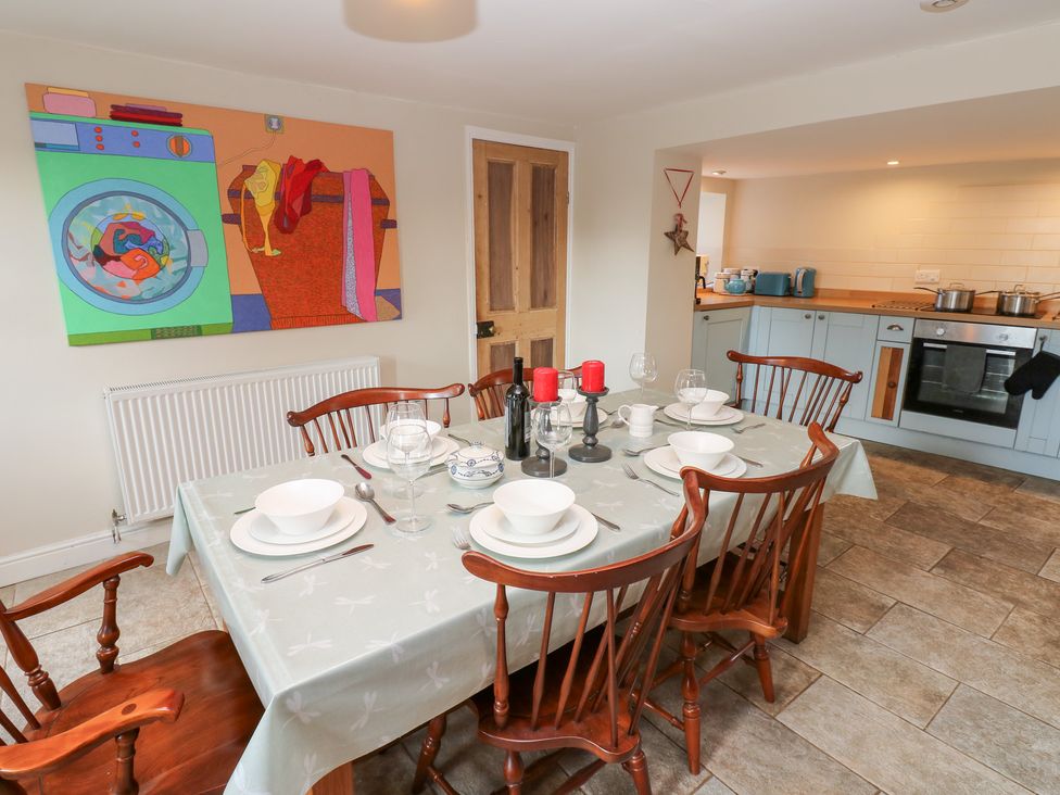 A dining room with a table set for meals at Rosemary Cottage Leyburn