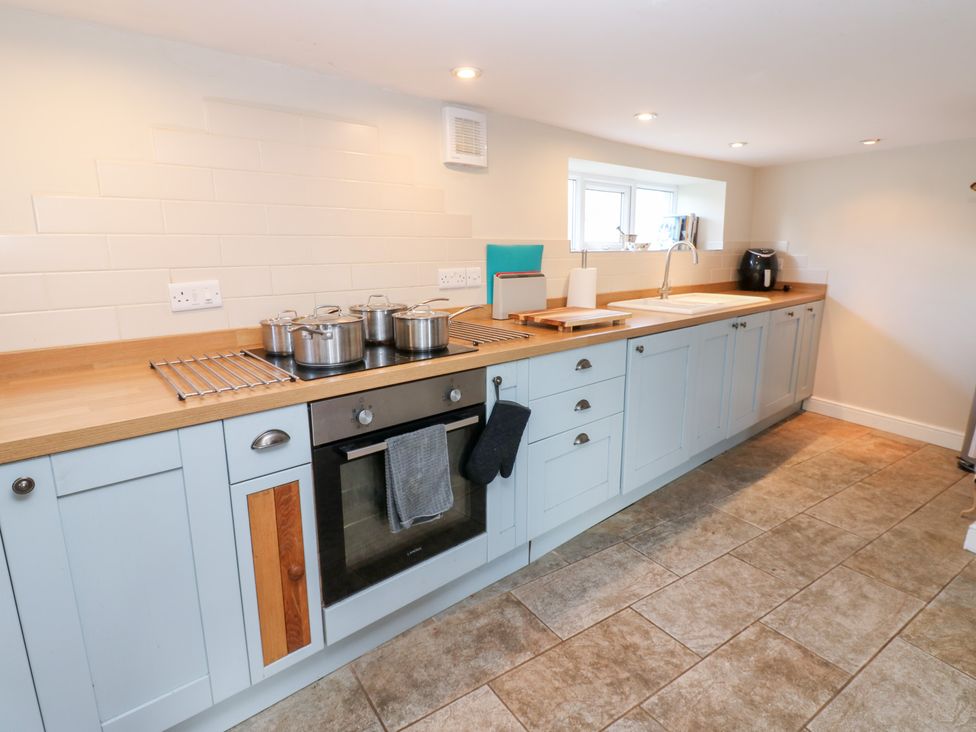 A kitchen with cabinets and pots on the countertop at Rosemary Cottage in Leyburn