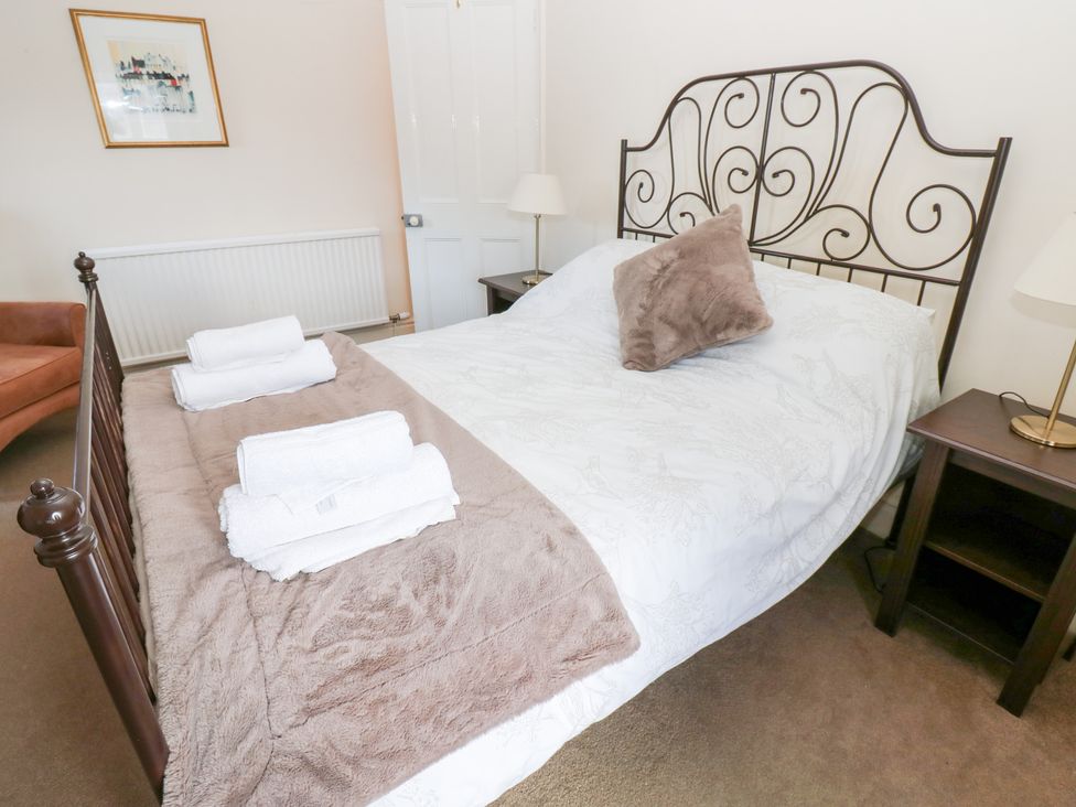 A bedroom with a bed and bedside table at Rosemary Cottage Leyburn