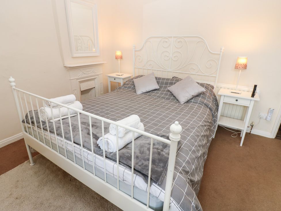 A bedroom with a bed and bedside table at Rosemary Cottage in Leyburn