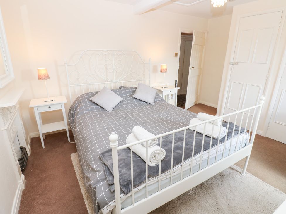 A bedroom with a bed and bedside tables at Rosemary Cottage Leyburn