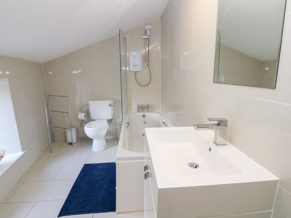 A bathroom with a bathtub, toilet and sink at Rosemary Cottage in Leyburn