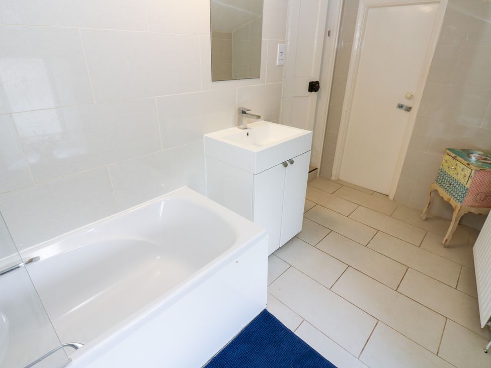 A bathroom with a bathtub and sink at Rosemary Cottage Leyburn