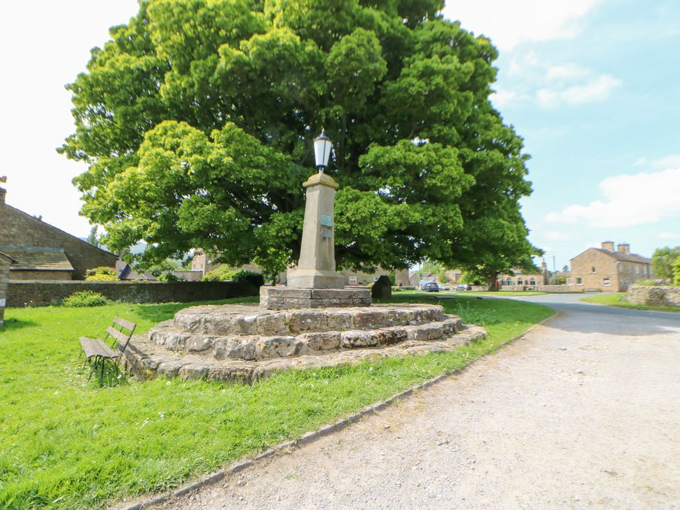 A monument surrounded by grass and a tree at Rosemary Cottage in Leyburn