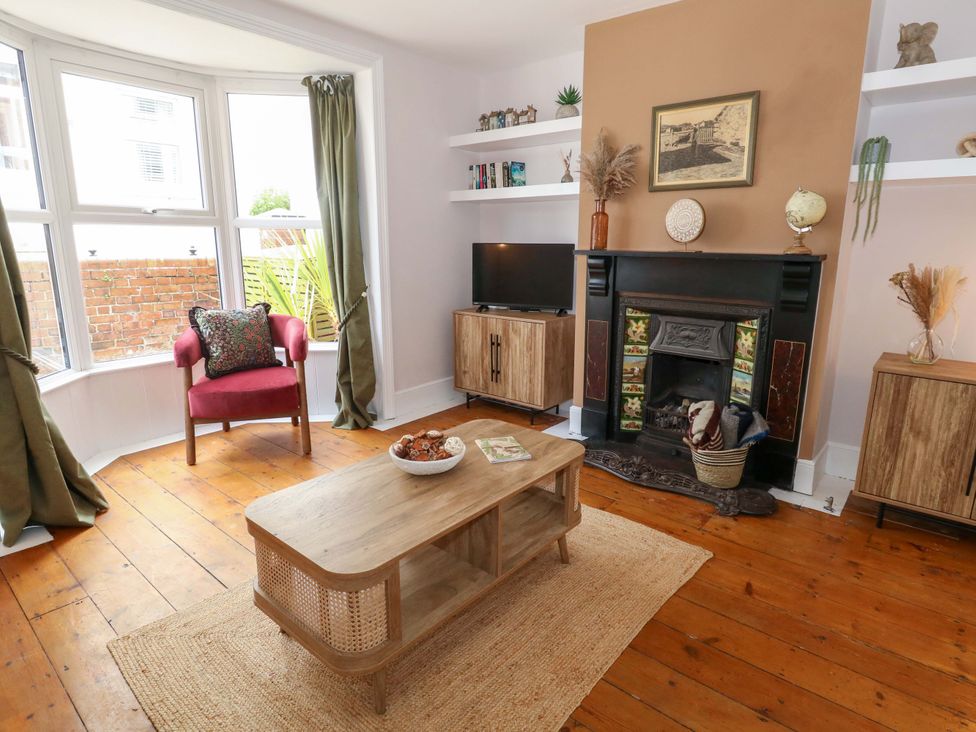 A living room with a chair and television at Otter Cottage in Weymouth