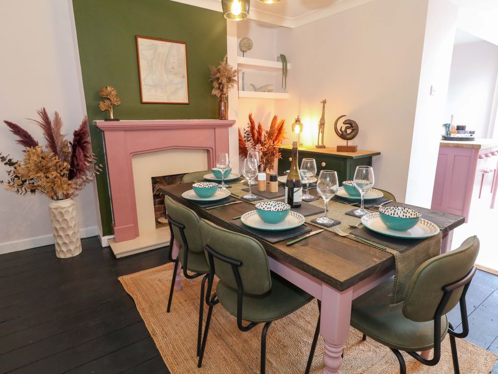 A dining room with a table set for dinner at Otter Cottage in Weymouth
