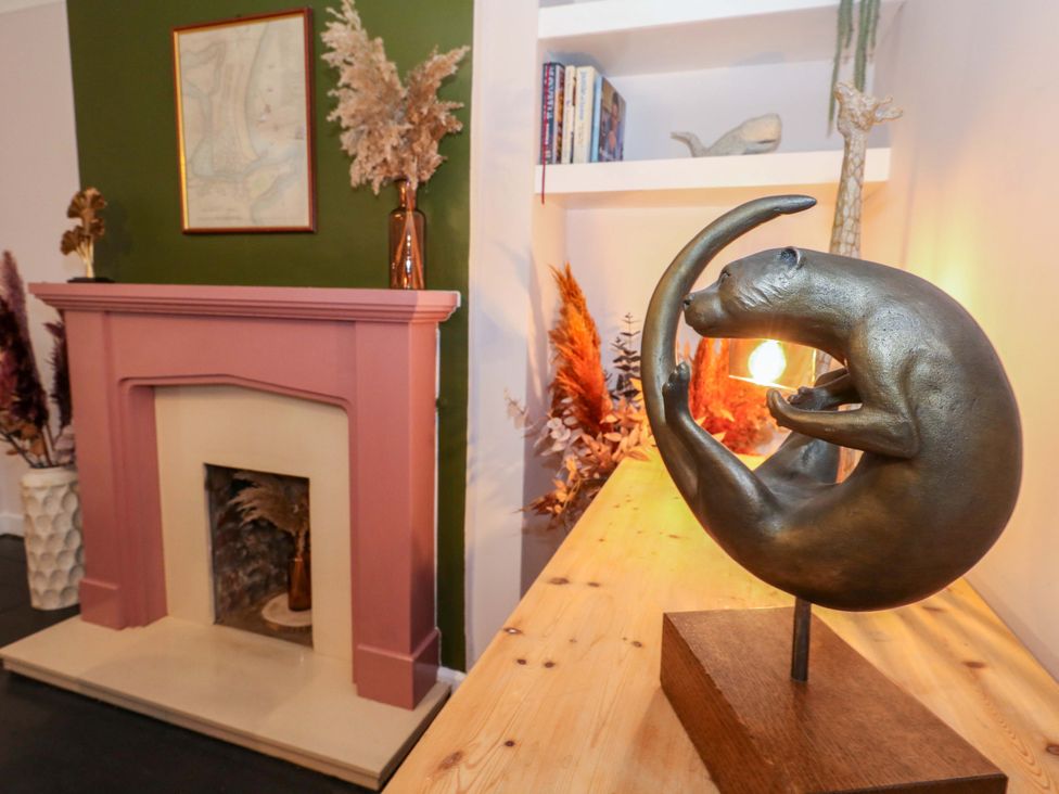 A living room with a sculpture and fireplace at Otter Cottage in Weymouth