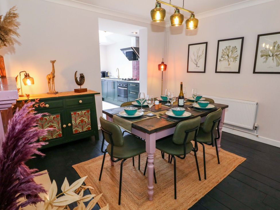 A dining room with a table set for dinner at Otter Cottage in Weymouth