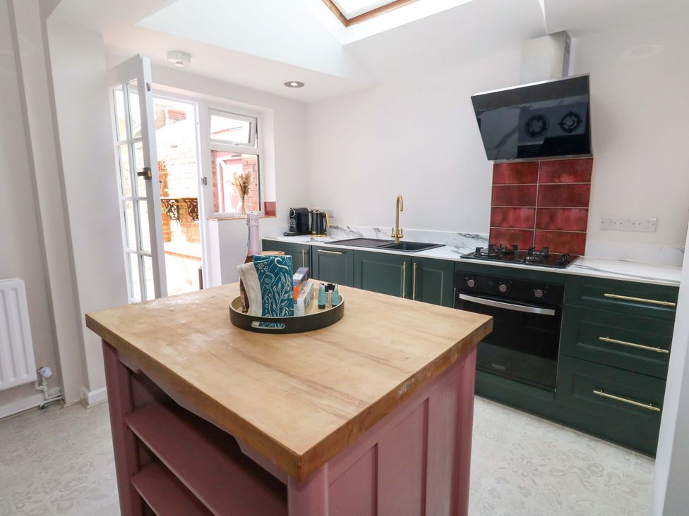 A kitchen with a cooking area and window at Otter Cottage Weymouth